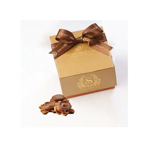 Gold gift box with a brown bow and 'Sweet Shop USA' branding, accompanied by chocolate truffles on a white background.